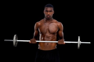 Fototapeta na wymiar Portrait of a serious fit young man lifting barbell