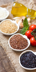 Variety of rice in bowls on wooden table
