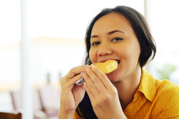 Pretty Young Attractive Woman Eating Donut  At Cafe