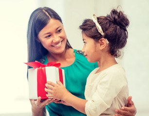 happy mother and child girl with gift box