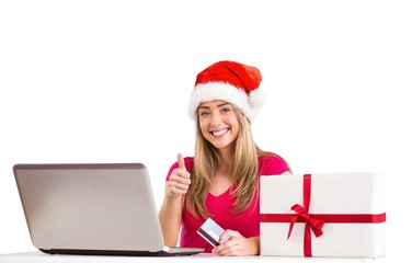 Festive blonde shopping online with laptop