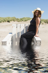 pregnant woman sitting on chair in the water