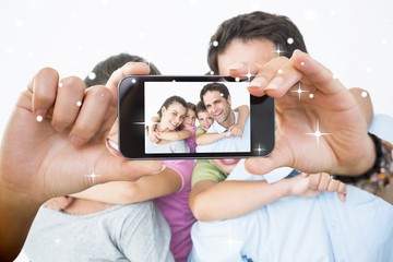 Composite image of hand holding smartphone