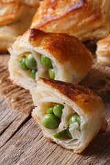 Pies of puff pastry with green peas close up  vertical
