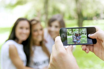 group of teenagers takes pictures with a smartphone