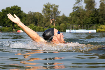 Man swims backstroke in a swimming pool