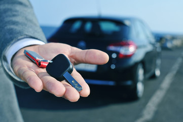 man offering a car key to the observer