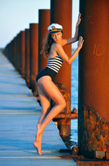 Sailor model posing sexy on the pier at the boat marina.