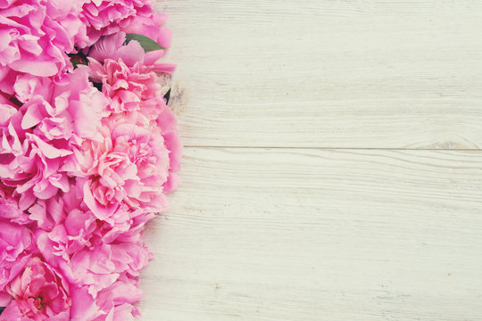 pink peonies on wooden surface