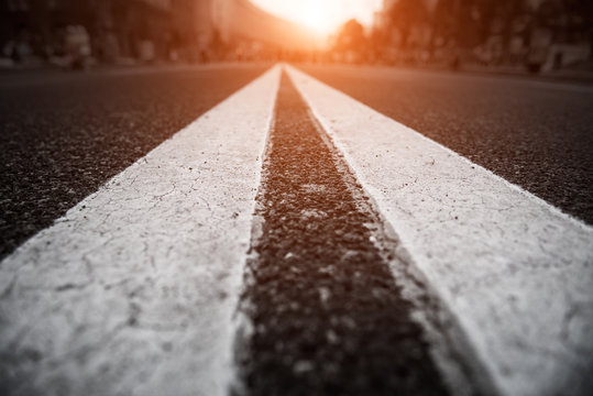 Asphalt City Road With White Lines Ahead And The Sunset