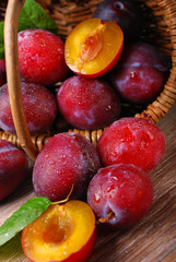 fresh plums falling out of a basket
