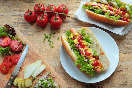 Two homemade hotdogs with sausages and fresh vegetables