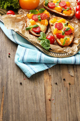 Tasty bruschetta with tomatoes, on old wooden table
