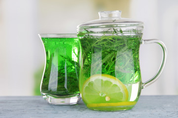 Estragon drink on wooden table on bright background