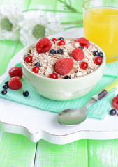 Tasty oatmeal with berries on table close-up