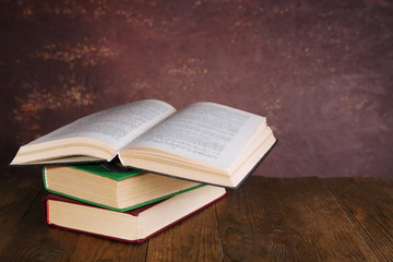 Books on wooden table on dark background