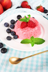 Round shaped cake with berries on plate on table cloth