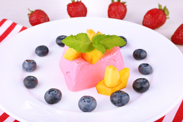 Heart shaped cake with fruits and berries on plate on napkin