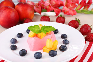 Heart shaped cake with fruits and berries on plate on napkin