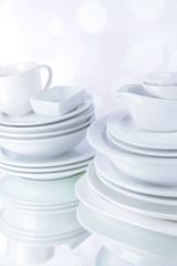 White crockery and kitchen utensils, on light background
