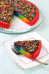 Delicious rainbow cake on plate, on tablecloth background