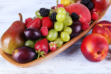 Different berries and fruits on wooden table close-up
