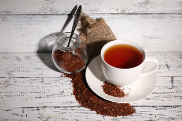 Cup of tasty rooibos tea, on old white wooden table © Africa Studio