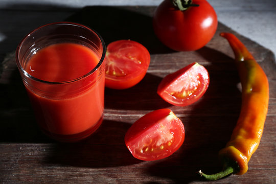 glass of tomato juice with spices and fresh tomatoes