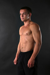 Fototapeta premium Handsome muscle young man on dark background