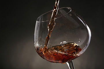 Red wine pouring into wine glass, close-up