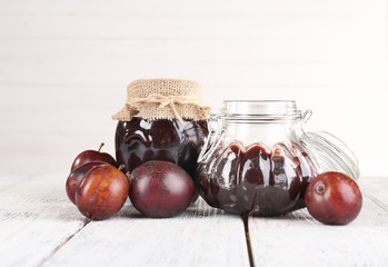 Plum jam and fresh plums in glass dish