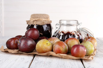 Plum jam and fresh plums in glass dish