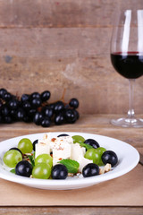 beautiful still life with wine and salad on wooden background