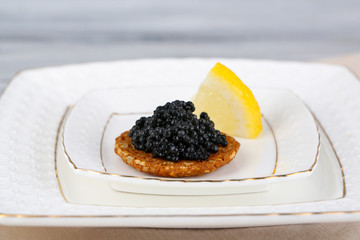 Black caviar on crispy bread on plate