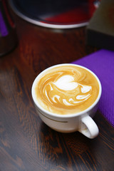 Cup of coffee with cute drawing in cafe