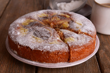 Delicious cake and cup of coffee on wooden table