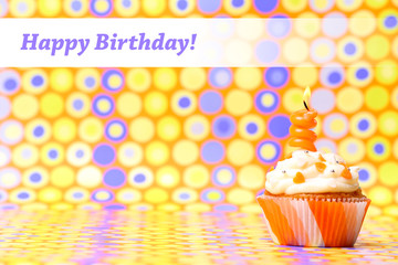 Delicious birthday cupcake on bright background