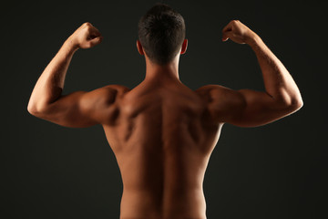 Fototapeta premium Handsome muscle young man on dark background