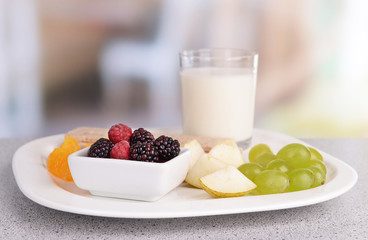 Slices of fruits with crispbreads and glass of milk