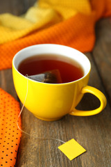 Cup of tea with tea bag on wooden table close-up