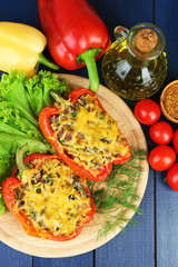 Stuffed red peppers with greens and vegetables on table close