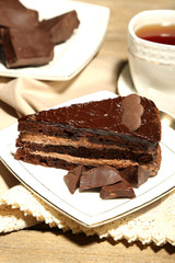 Chocolate cake on plate, on wooden background