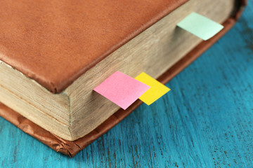 Book with bookmarks on wooden background