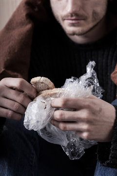 Homeless man eating sandwich