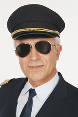 Flugkapitän vor weißem Hintergrund,lächelnd