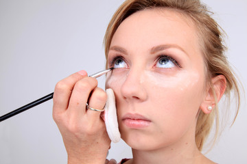 Fototapeta premium Makeup artist applying makeup to model