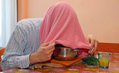 man with towel breathe balsam vapors to treat colds and the flu