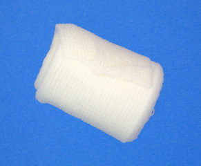 Roll of first aid gauze bandage on a blue background