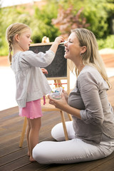 Junges Mädchen und ihre Mutter spielen draußen