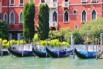 Fototapeta na wymiar Gondolas at berth of the Grand Canal near the picturesque mansio